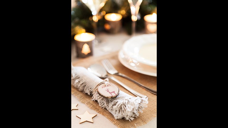 Ferma-tovagliolo a tema: in alternativa alle creazioni artistiche, &egrave; possibile chiudere i tovaglioli con decorazioni a tema. Vanno benissimo anche quelle per l&rsquo;albero di Natale, basta infilarle in un cordoncino sottile.&nbsp;