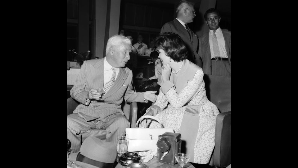Charlie Chaplin mentre conversa con l'attrice Dawn Addams, settembre 1957