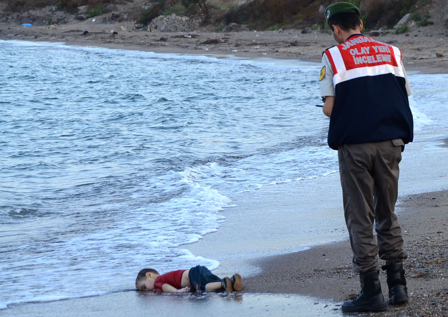 Il cadavere di un bambino migrante, Aylan Shenu, al largo delle coste a Bodrum, Turchia meridionale. La nave che trasportava profughi &egrave; affondata per raggiungere l'isola greca di Kos (2 settembre)