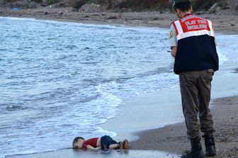 Il cadavere di un bambino migrante, Aylan Shenu, al largo delle coste a Bodrum, Turchia meridionale. La nave che trasportava profughi &egrave; affondata per raggiungere l'isola greca di Kos (2 settembre)