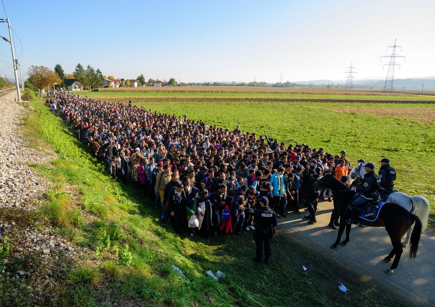 La polizia scorta i migranti e richiedenti asilo in un centro profughi dopo aver attraversato il confine croato-sloveno vicino Rigonce (24 ottobre 2015)