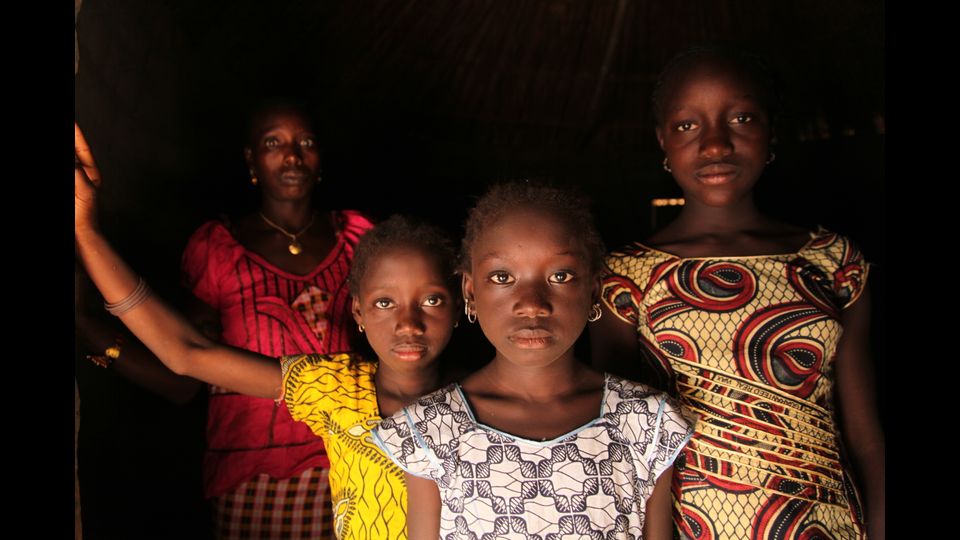 Guinea-Bissau, 2012. Una donna e le sue figlie nella loro casa nel villaggio di Cambadju, il primo nel paese ad aver abolito la pratica dell'escissione