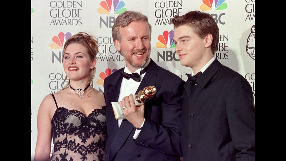 Il regista James Cameron (C) con Kate Winslet e Leonardo DiCaprio posano per i fotografi dopo la consegna della statuetta per la migliore regia per Titanic (1997) ai 55* Golden Globe Awards (Afp)