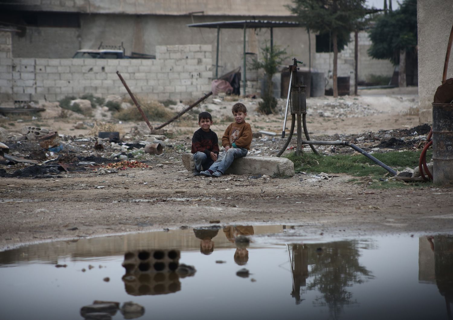 Bambini si siedono vicino ad un pozzo in una zona assediata nel Ghouta orientale (foto Amer Al Shami per Save the Children)&nbsp;