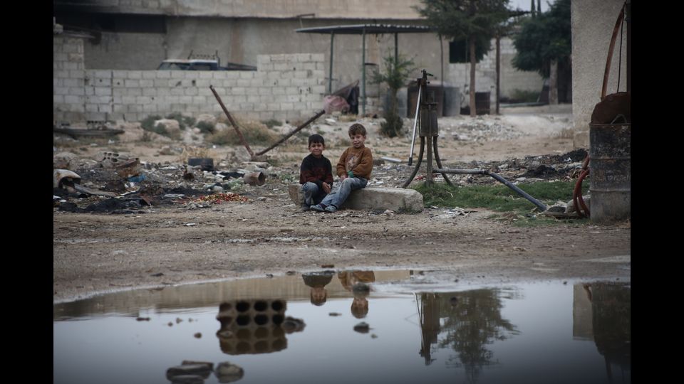 Bambini si siedono vicino ad un pozzo in una zona assediata nel Ghouta orientale (foto Amer Al Shami per Save the Children)&nbsp;