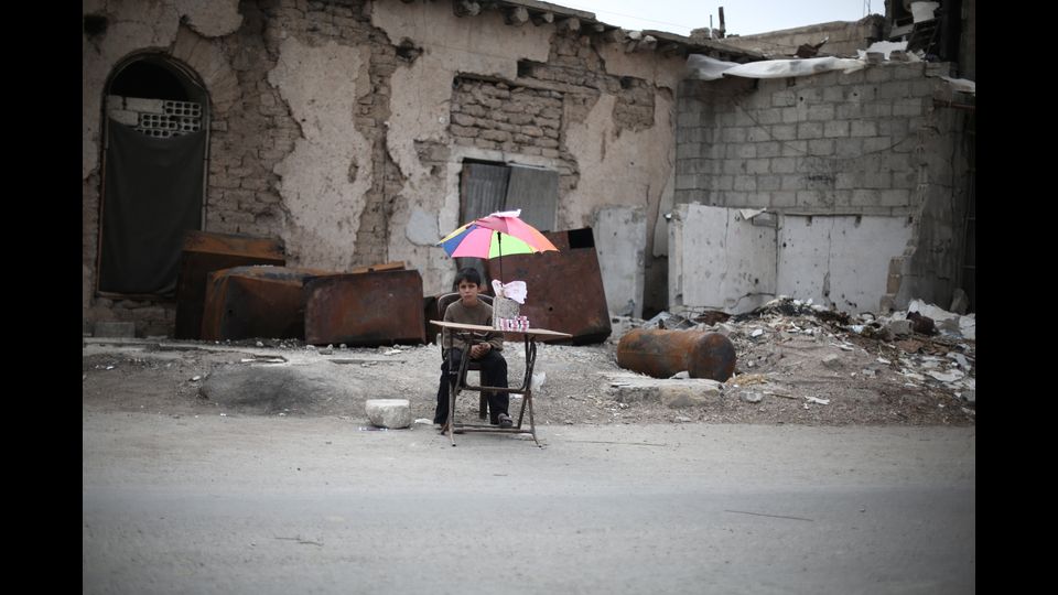 Un bambino vende biscotti sul ciglio della strada nel Ghouta orientale (foto Amer Al Shami per Save the Children)&nbsp;