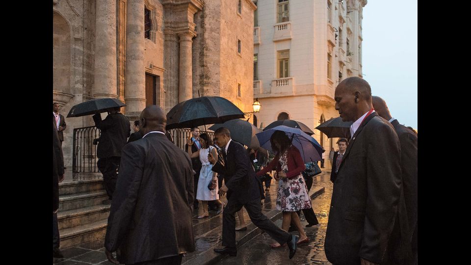 &nbsp;Sotto una pioggia torrenziale, Obama e Michelle entrano nella Cattedrale di Los Angeles (foto Afp)