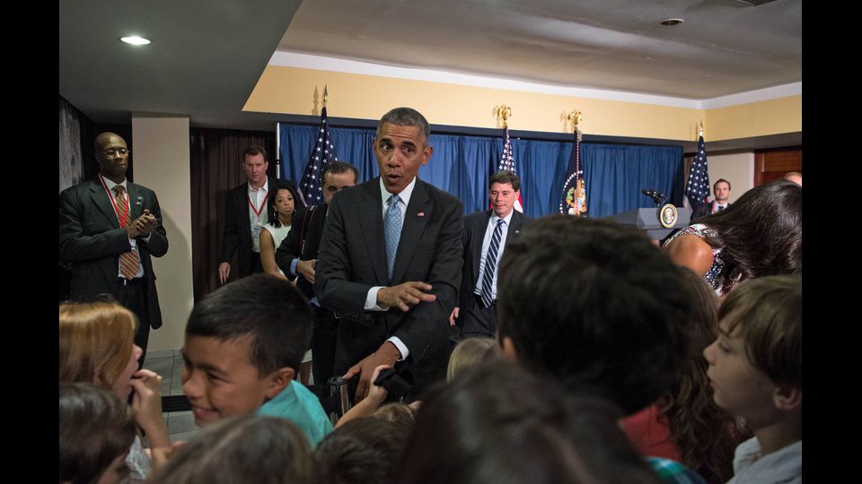 &nbsp;Obama durante la sua visita all'Ambasciata Usa, scherza e ride con i bambini (foto Afp)