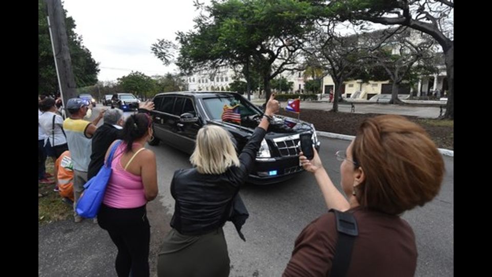 &nbsp;Un gruppo di cubani fotografa il passaggio dell'auto del presidente Obama a Piazza della Rivoluzione (foto Afp)