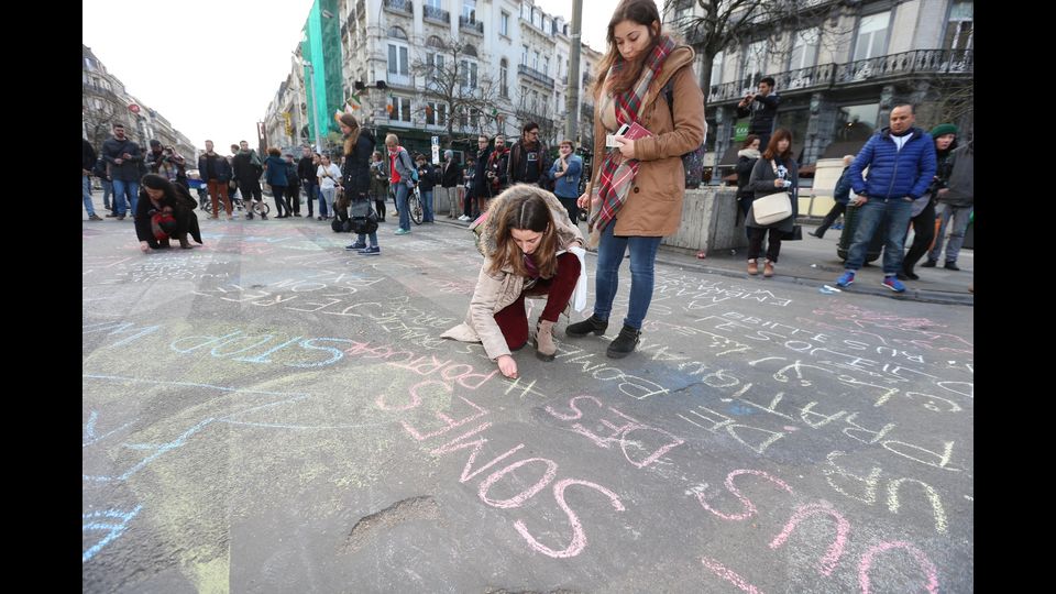 Davanti alla Borsa a Bruxelles scrivono col gesso messaggi pace (Afp)