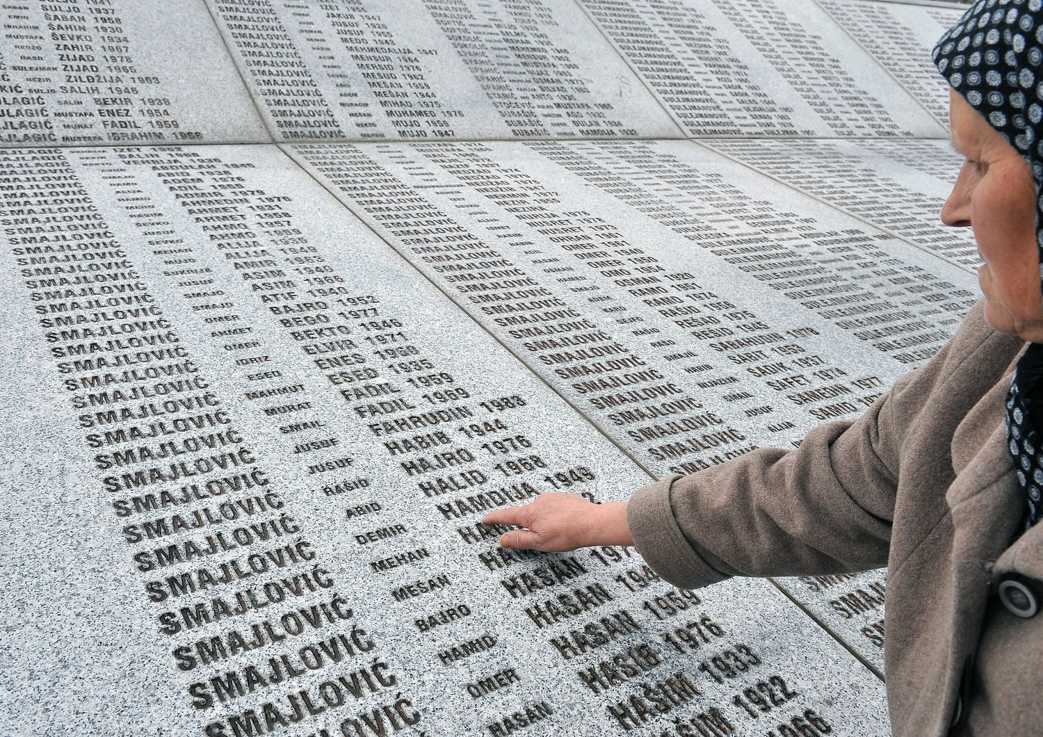 Una donna accarezza i nomi delle 8 mila vittime del genocidio di Srebrenica