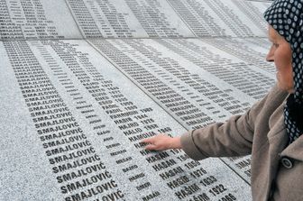 Una donna accarezza i nomi delle 8 mila vittime del genocidio di Srebrenica
