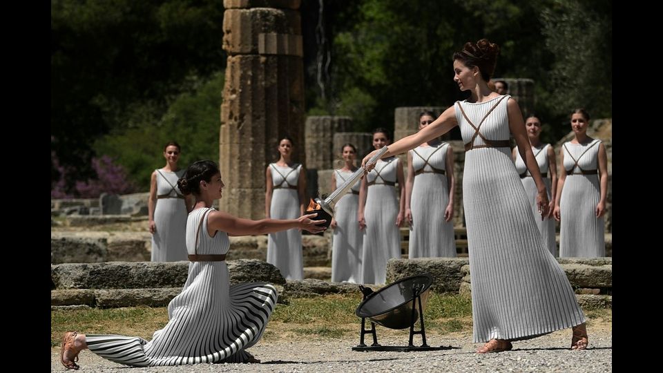 &nbsp; Katerina Lexou porge la torcia accesa con la fiamma Olimpica &nbsp;ad un'altra attrice durante la cerimonia di accensione al Tempio di Hera (foto Afp)