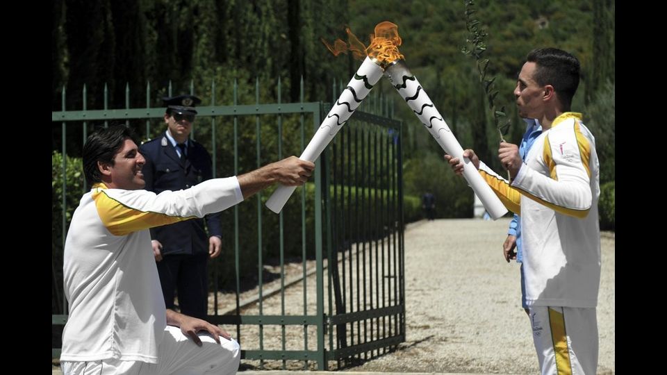 &nbsp;Il campione del mondo di ginnastica artistica Lefteris Petrounias, primo tedoforo, passa la fiamma Olimpica al secondo tedoforo, il giocatore di pallavolo brasiliano Giovane Gavio (foto Afp)