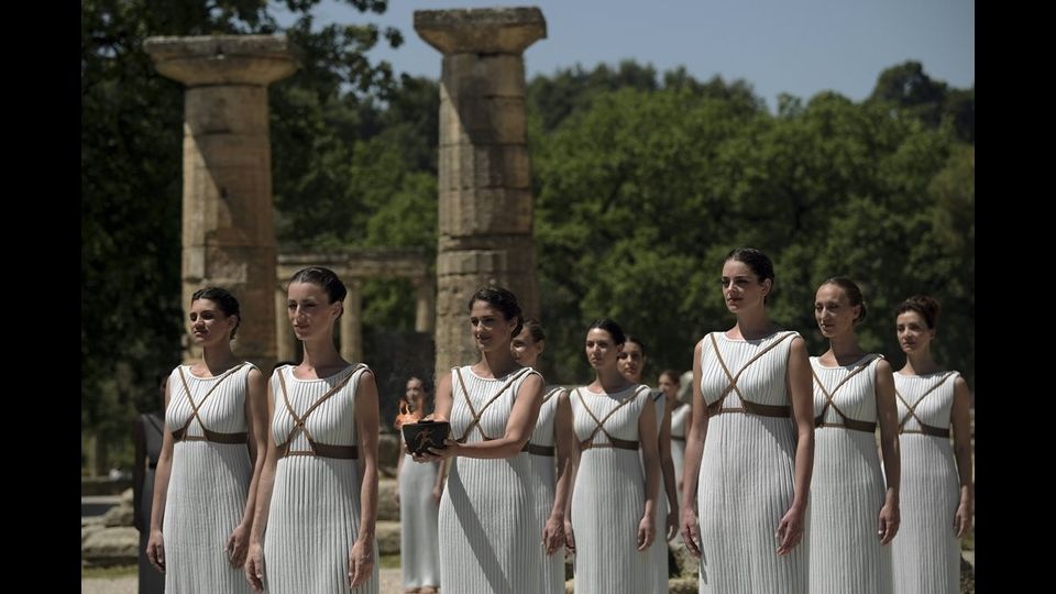&nbsp; Una delle attrici, nelle vesti di Sacerdotessa, mostra la pentola con la fiamma Olimpica (foto Afp)