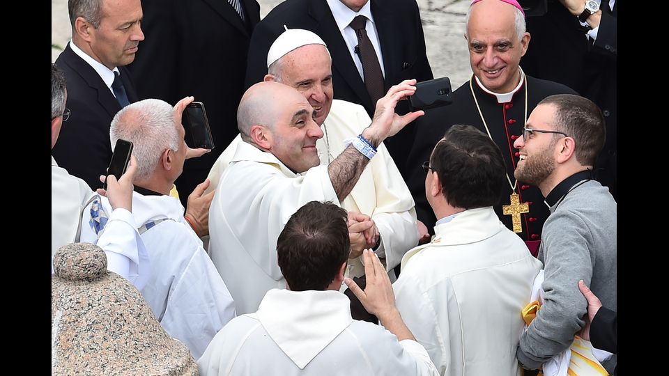 Papa Francesco posa per un selfie con alcuni giovani preti dopo la messa per la giornata dei ragazzi dell'anno giubilare (Afp)