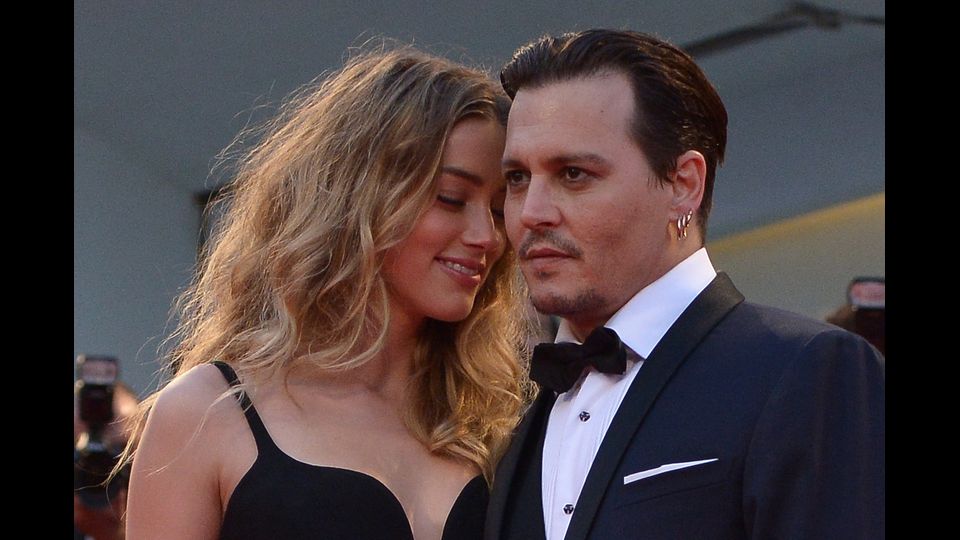 L'attore americano Johnny Depp e sua moglie, l'attrice americana Amber Heard, alla prima del film &quot;messa nera&quot; presentato fuori concorso al 72esmo Festival di Venezia. Settembre 2015 (Afp)