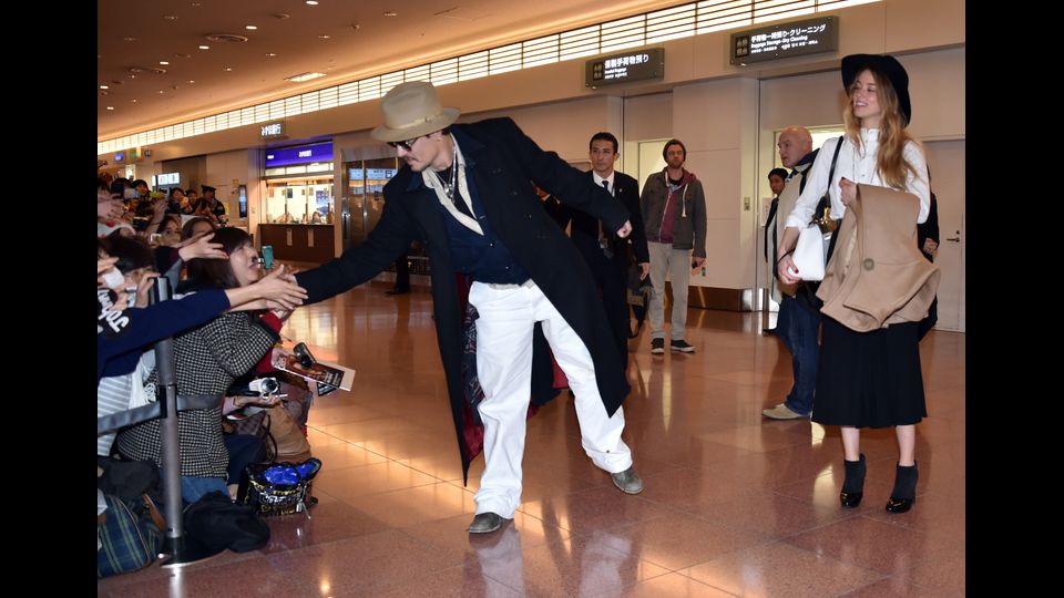 L'attore americano Johnny Depp accompagnato dall'attrice statunitense e modella Amber Heard accolti dai fan all'aeroporto internazionale di Tokyo (Afp)