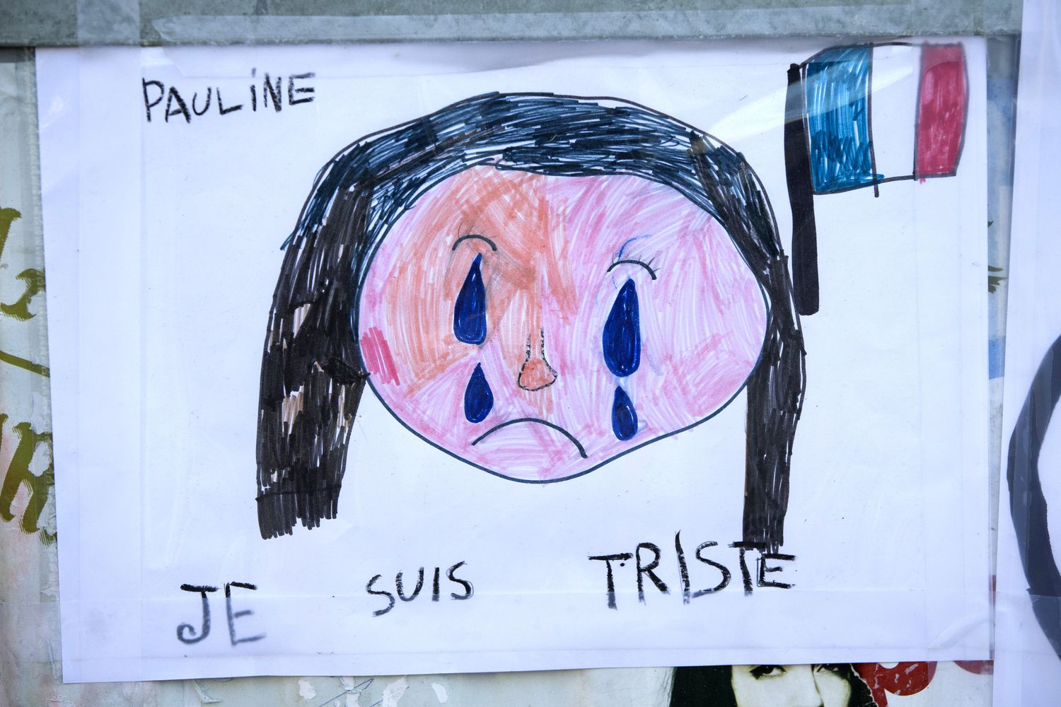 Il disegno di una bambina dopo gli attentati di Parigi pianto (afp)&nbsp;