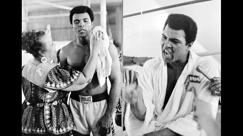 Muhammad Ali  a Kinshasa il 27 Ottobre 1974 durante un allenamento pochi giorni prima di conquistare il titolo di campione del mondo della boxe dei pesi massimi contro il connazionale George Foreman.Foto da sinistra:, la madre si prende cura di lui. Immagine a destra: Mohamed  risponde alle domande dei giornalisti 27 settembre 1974 a Kinshasa pochi giorni prima di vincere l'incontro contro  George Foreman. &nbsp;