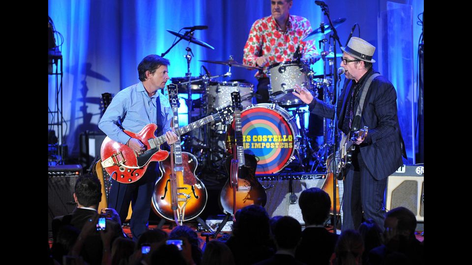 Novembre 2012: l'attore con Elvis Costello durante un evento in favore della manifestazione annuale per la ricerca delle cure contro il morbo di Parkinson (Afp)