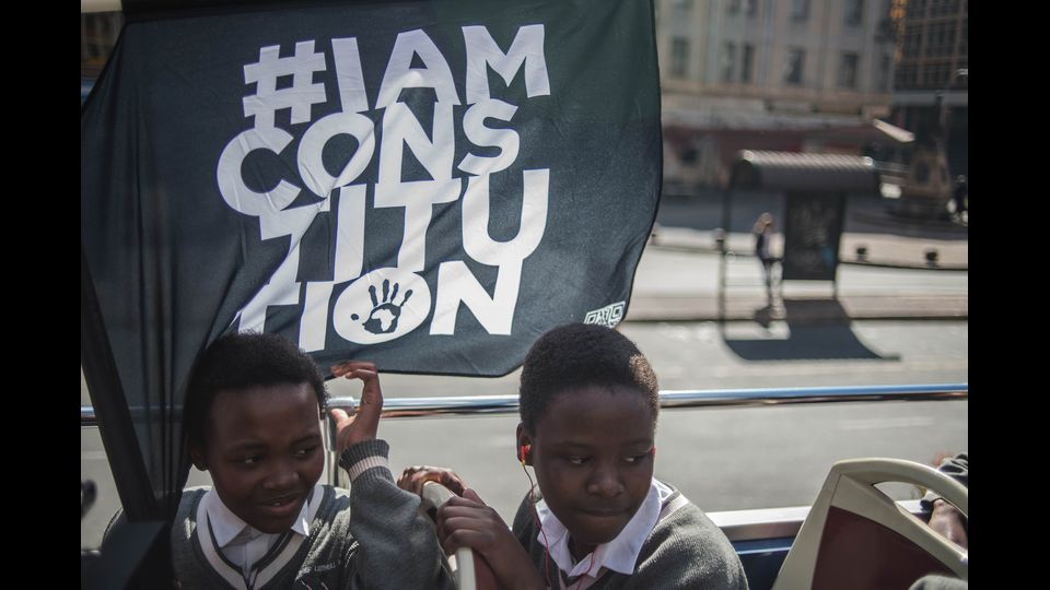 Studenti nelle scuole ricordano il massacro di Soweto, la bandiera simbolo con la scritta 'Io sono la Costituzione' (Afp)