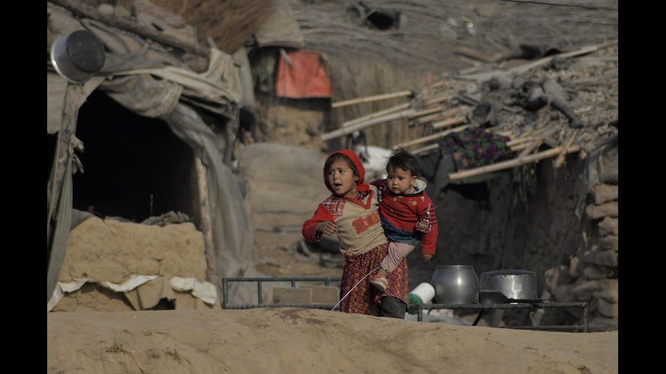 Bambini afgani in cammino verso un villaggio profughi di Islamabad, in Pakistan (foto Afp)  &nbsp;