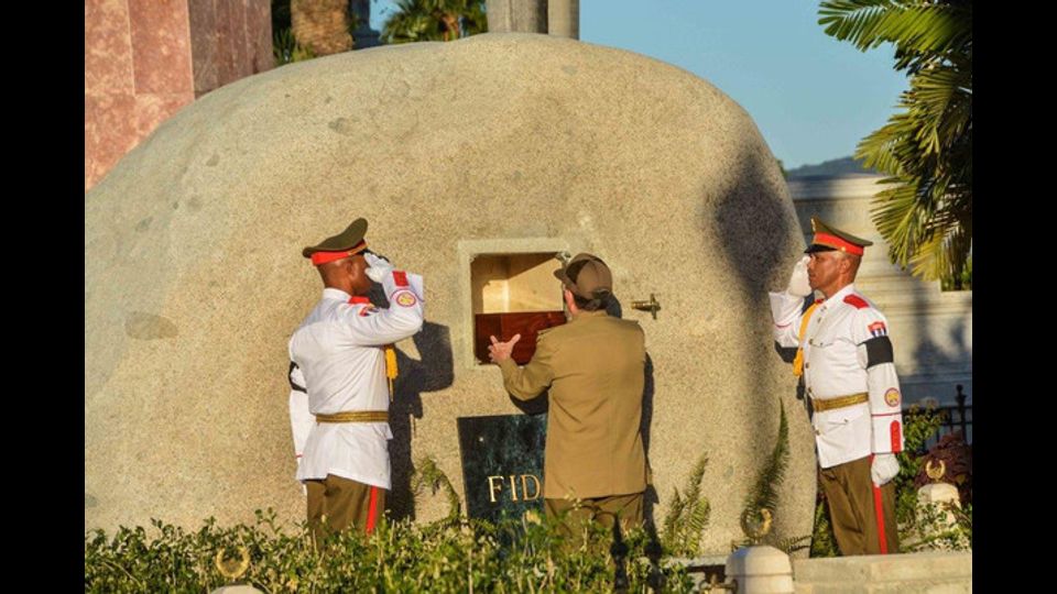 Il presidente cubano Raoul Castro pone l'urna con le cenri del fratello Fidel nella tomba del cimitero di Santa Ifigenia a Santiago di CUba (Foto Afp)&nbsp;