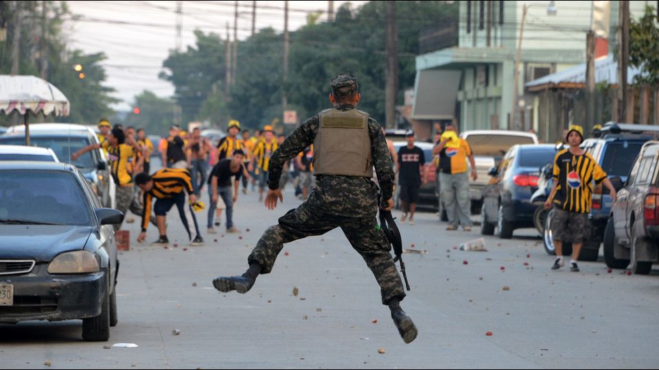 Soldato preso a sassate dai tifosi del Real Espana in Honduras (Foto Afp)