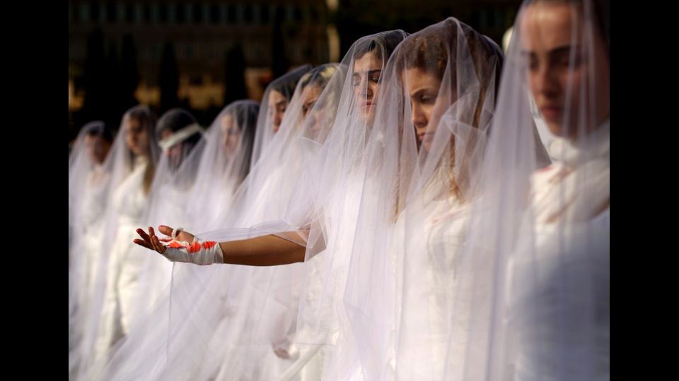 Attiviste delle Ong libanesi Abaad vestite da spose, mostrano le mani ferite, in segno di protesta contro la legge che protegge e tutela gli stupratori dal processo, a condizione che sposino la loro vittima (Foto Afp)&nbsp;