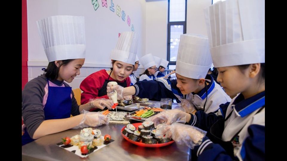 &nbsp;Giovani studenti della scuola di Hobbot a Pechino imparano a fare il sushi (Foto Afp)