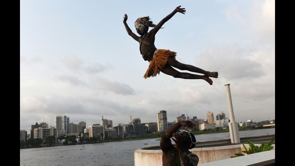 &nbsp;Costa D'Avorio, un uomo osserva il volteggio di una bambina prima di un concorso internazionale di danza organizzato al Palazzo della Cultura di Abidjan (Foto Afp)