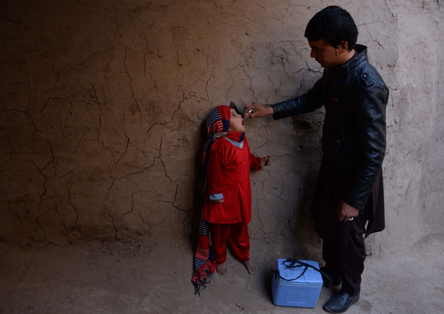 Un operatore sanitario afghano somministra antipolio a un bambino durante una campagna di vaccinazione alla periferia di Jalalabad. La poliomielite è una piaga in tutto di mondo, endemica in soli tre paesi: Afghanistan, Nigeria e Pakistan (foto Afp)