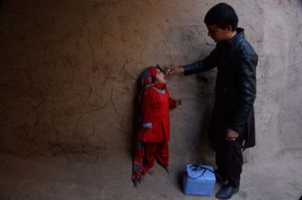 Un operatore sanitario afghano somministra antipolio a un bambino durante una campagna di vaccinazione alla periferia di Jalalabad. La poliomielite è una piaga in tutto di mondo, endemica in soli tre paesi: Afghanistan, Nigeria e Pakistan (foto Afp)