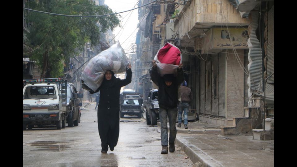 Civili in fuga mentre infuria la battaglia ad Aleppo Est (foto Afp)&nbsp;