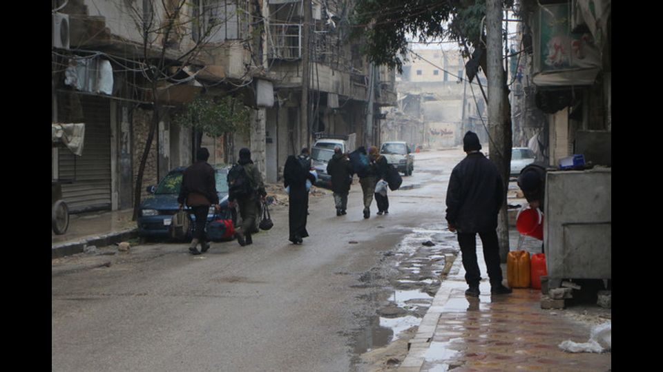 Civili in fuga mentre infuria la battaglia ad Aleppo Est (foto Afp)&nbsp;