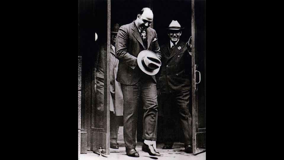 &nbsp;Al (Alphonse) &quot;Scarface&quot;, Capone, (1899-1947) il boss noto per le attivit&agrave; di contrabbando nell'era del proibizionismo a Chigaco, mentre lascia il tribunale di Atlanta con il suo cappello a coprire le manette. Novembre 1932 (foto Afp)