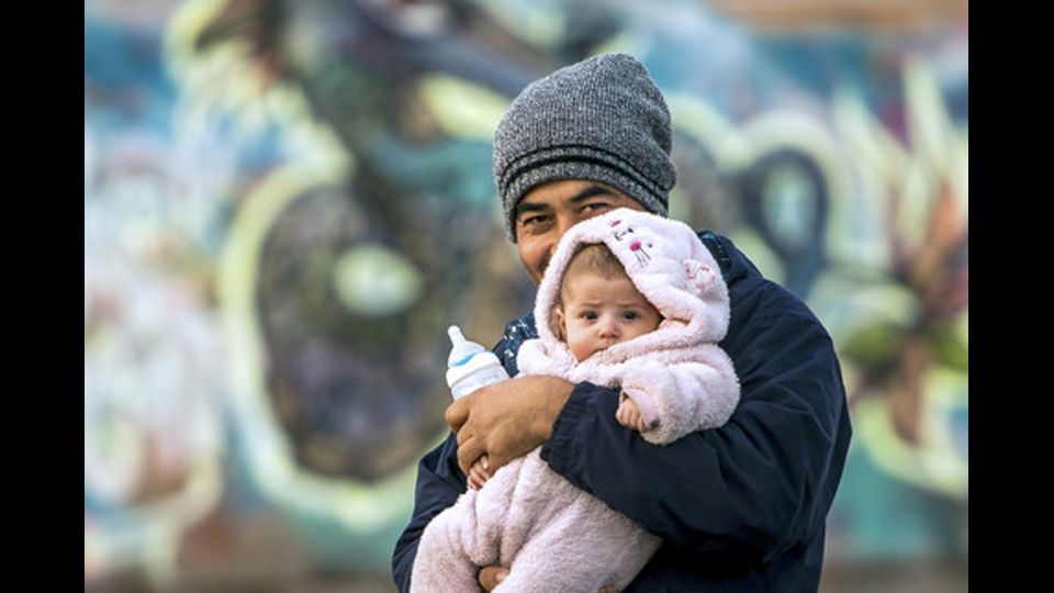 Un migrante afghano con la figlia di 2 mesi in un campo profughi a Grande-Synthe, Francia (14 dicembre 2016) (foto Afp) &nbsp;