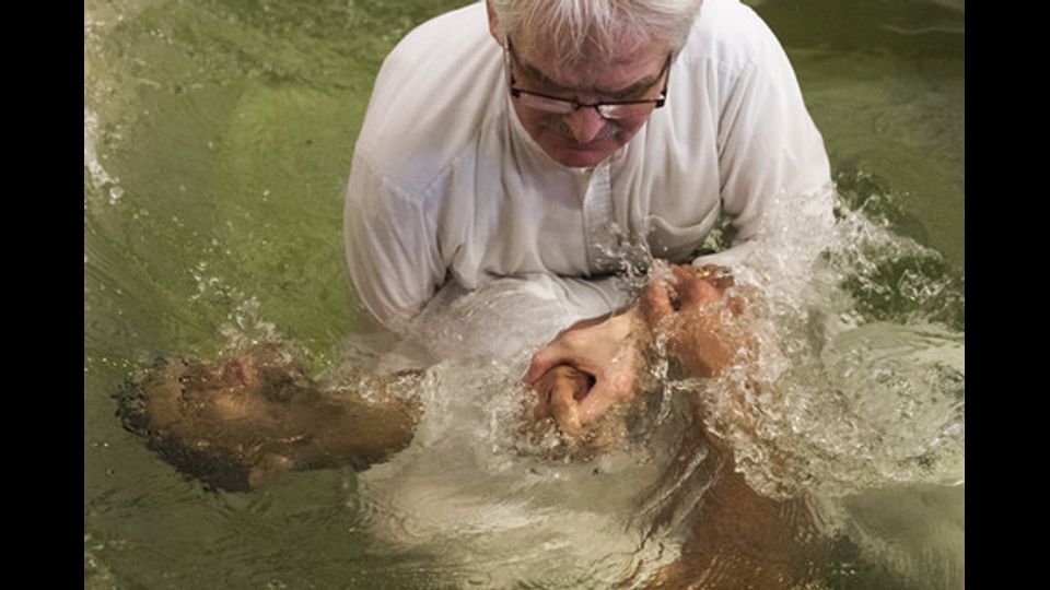 Un pastore della chiesa Evangelisch-Freikirchliche Gemeinde battezza un rifugiato musulmano appena convertito nel corso di una cerimonia tenutasi a Berlino. Quattro profughi musulmani, due dall'Afghanistan e dall'Iran sono stati battezzati durante la cerimonia (il 27 novembre 2016) (foto Afp) &nbsp;