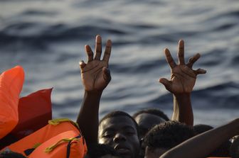 Migranti e rifugiati cercano di afferrare giubbotti di salvataggio gettati dai membri dell'equipaggio al largo della costa libica nel Mar Mediterraneo (3 novembre 2016) (foto Afp)&nbsp;