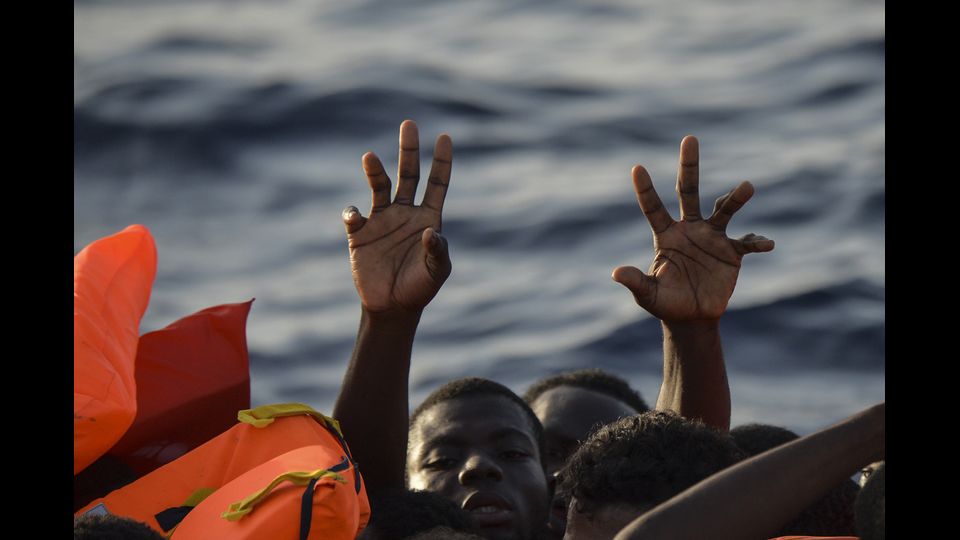 Migranti e rifugiati cercano di afferrare giubbotti di salvataggio gettati dai membri dell'equipaggio al largo della costa libica nel Mar Mediterraneo (3 novembre 2016) (foto Afp)&nbsp;