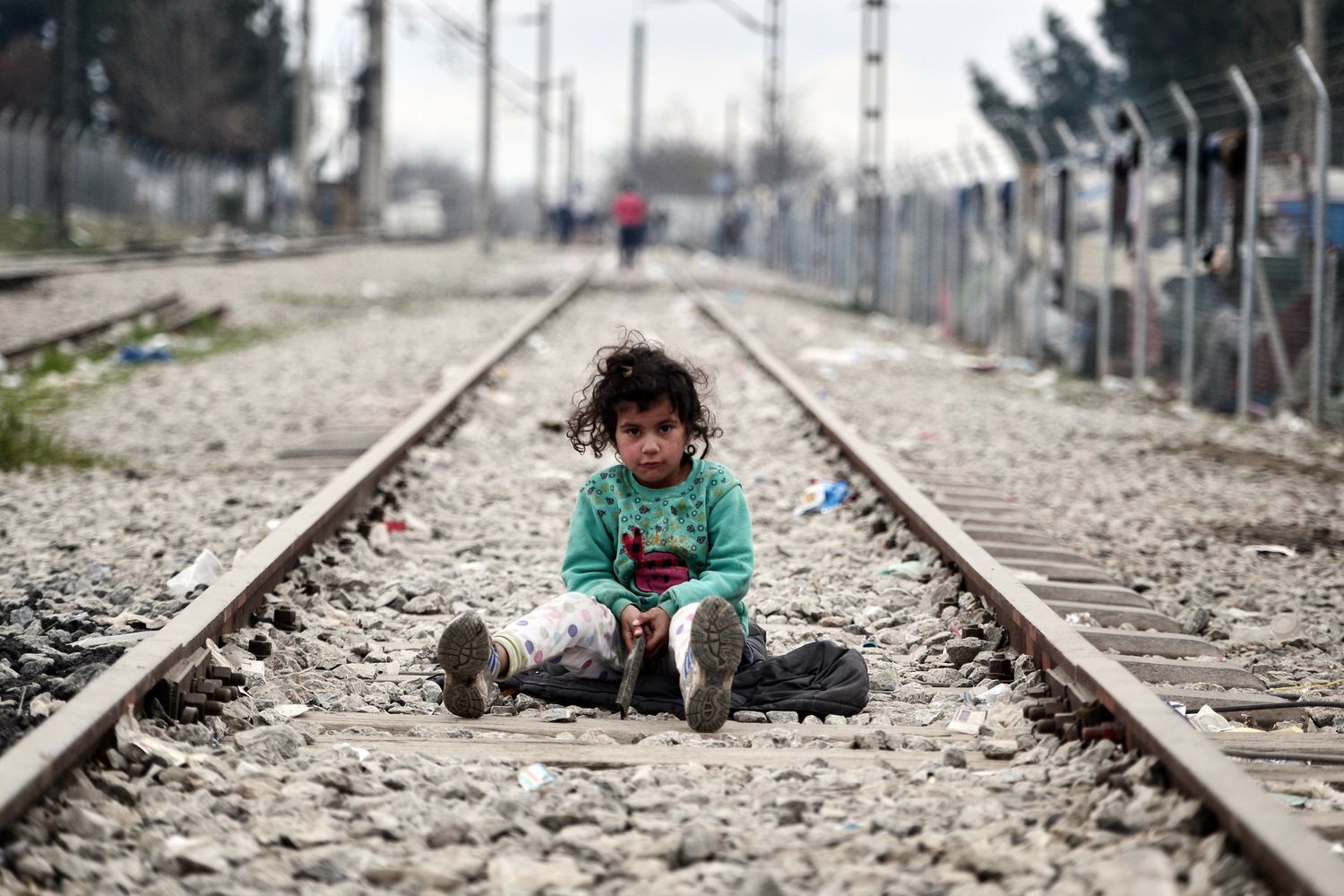 Una bambina gioca sui binari del treno lungo il confine greco-macedone, nel villaggio di Idomeni dove vivono migliaia di migranti e rifugiati. (foto Afp)