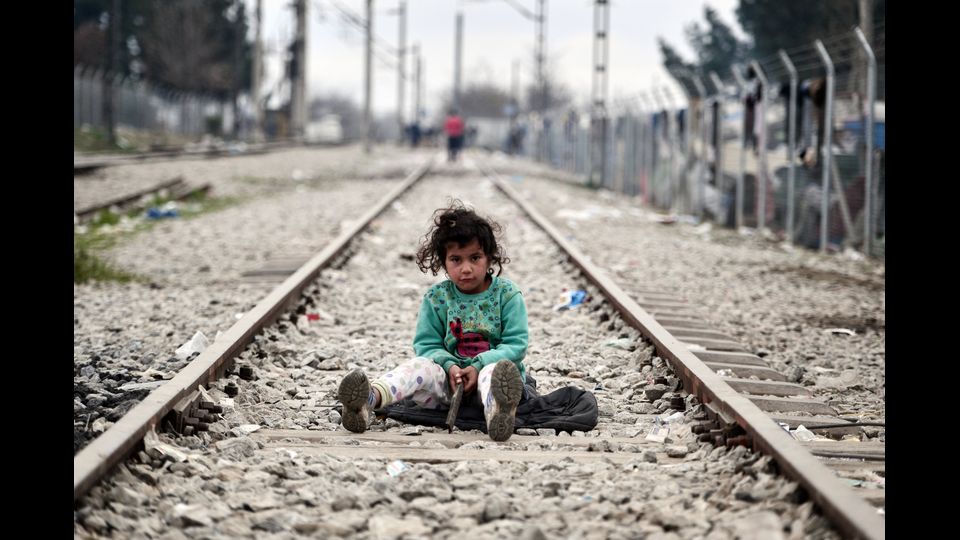 Una bambina gioca sui binari del treno lungo il confine greco-macedone, nel villaggio di Idomeni dove vivono migliaia di migranti e rifugiati. (foto Afp)