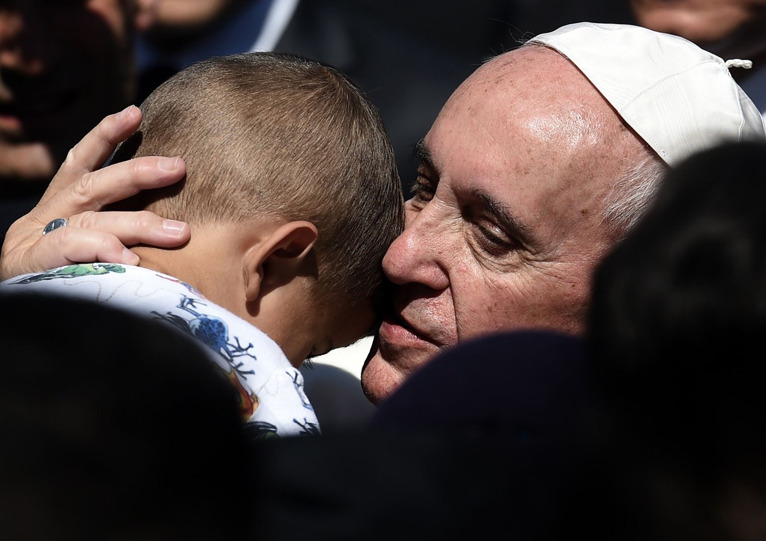 Papa Francesco abbraccia un bambino al centro rifugiati di Moria a Mytilene il 16 aprile 2016 (foto Afp)