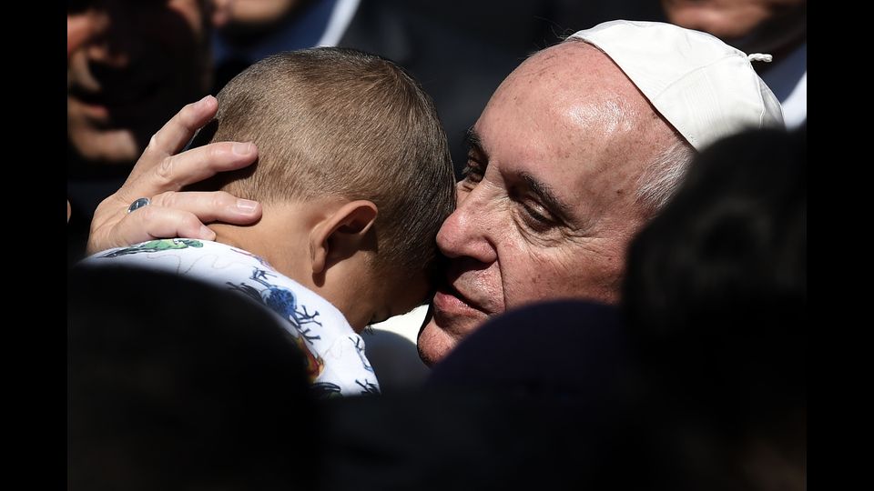 Papa Francesco abbraccia un bambino al centro rifugiati di Moria a Mytilene il 16 aprile 2016 (foto Afp)