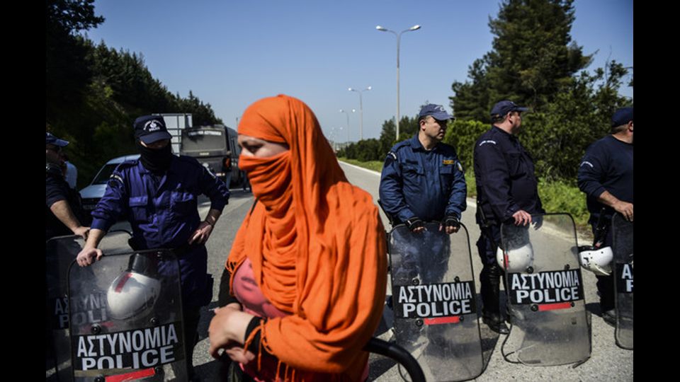 Una migrante affronta la polizia greca a Idomeni. La foto scattata il 4 aprile 2016, giorno in cui e' stata lanciata l'operazione di rimpatrio verso la Turchia di 200 migranti economici (foto Afp)