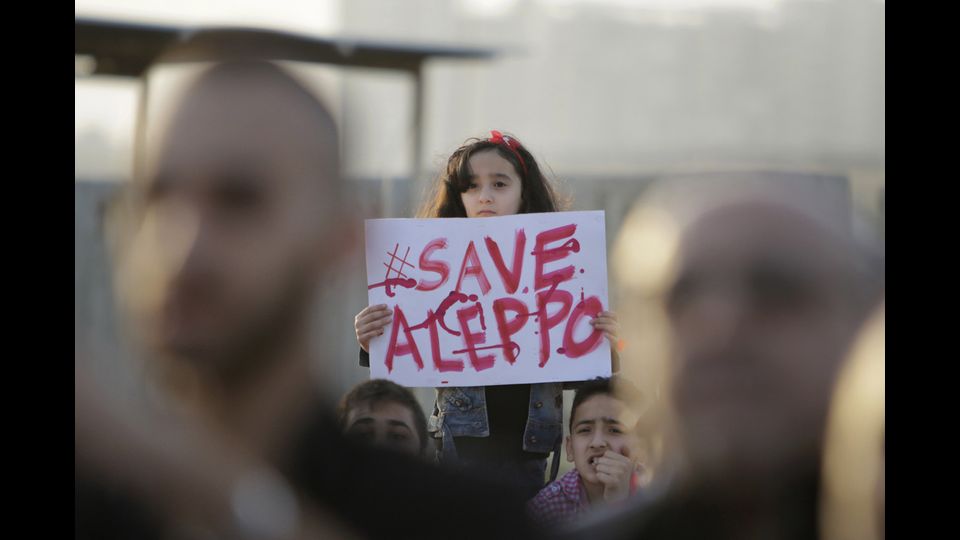 Nella citt&agrave; libanese di Tripoli una ragazza siriana esibisce un cartello durante una manifestazione di solidariet&agrave; con Aleppo. E' il primo maggio e una settimana di feroci combattimenti nella seconda citt&agrave; della Siria &egrave; costata la vita a centinaia di persone (foto Afp)&nbsp;