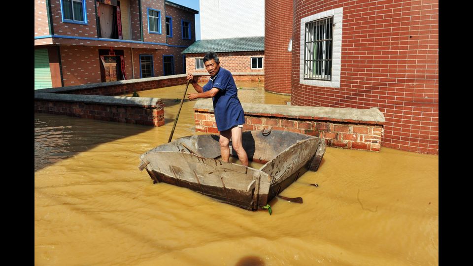 Inondazioni in un villaggio della contea di Poyang, nella provincia cinese di Jiangxi. Le forti piogge hanno causato 22 morti (foto Afp)