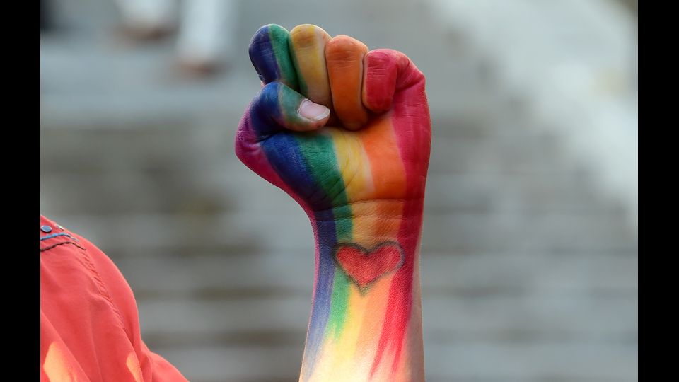 Un pugno alzato con i colori dell'arcobaleno in onore delle vittime della strage di Orlando, nel corso di una veglia al&nbsp;Los Angeles City Hall il 13 giugno (foto Afp)