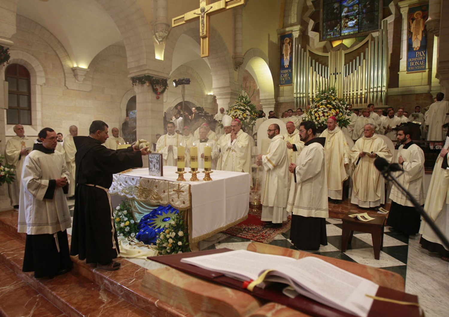 L'Arcivescovo di Gerusalemme, Pierbattista Pizzaballa, durante la messa di Natale nella Chiesa di Santa Caterina presso la Chiesa della Nativit&agrave; a  Betlemme, alla funzione religiosa ha partecipato anche il presidente palestinese Mahmoud Abbas (foto Afp)&nbsp;